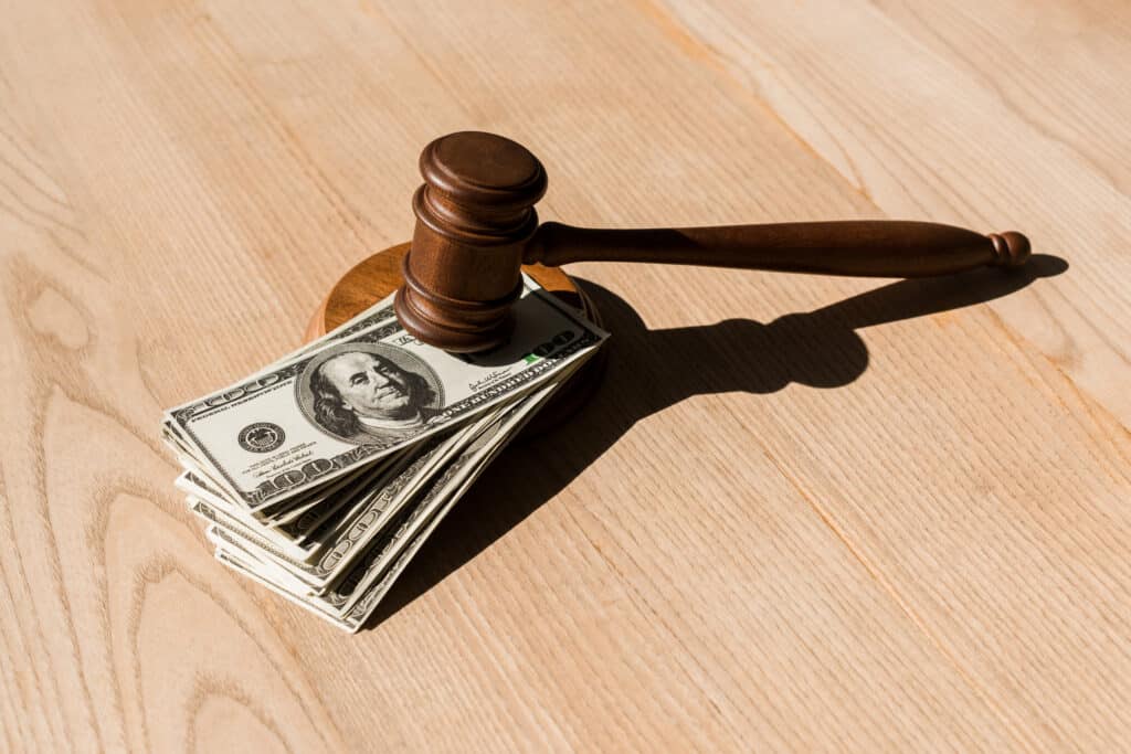 photo of a gavel on a stack of hundred dollar bills
